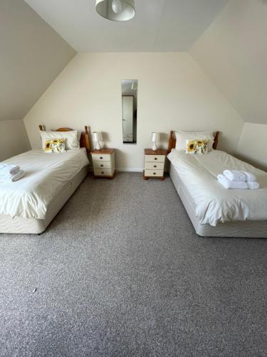 1 dormitorio con 2 camas y espejo en Self Catering house with lovely sea views, 44 Back en Vatisker