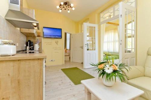 eine Küche und ein Wohnzimmer mit einem Sofa und einem Tisch in der Unterkunft Villa Waldschloss, App 05 in Heringsdorf