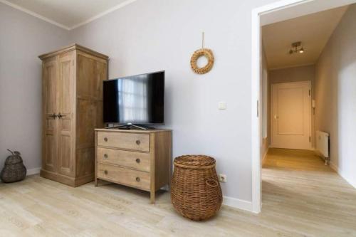 sala de estar con TV y tocador de madera en Villa Brunnenstraße, App 1, en Heringsdorf