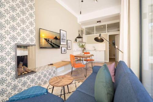 un soggiorno con divano blu e tavolo di Villa Bellevue App 02 a Heringsdorf