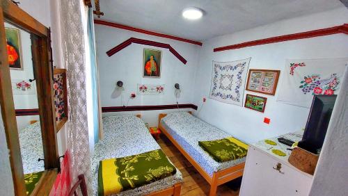 a small room with two beds and a television at Vila Milenovic Rajacke Pivnice in Rajac