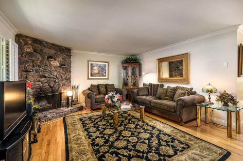 una sala de estar con sofás y una pared de piedra. en Creme De La Creme 1 Pet Friendly Home en Groveland