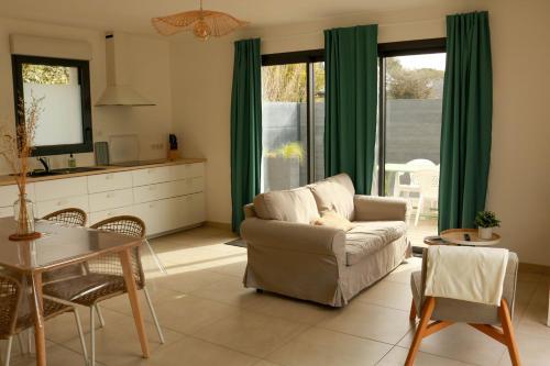 ein Wohnzimmer mit einem Sofa und einem Tisch in der Unterkunft Gîtes de Lauvergnac - Maisons 2 Ch, 2 SdB in La Turballe