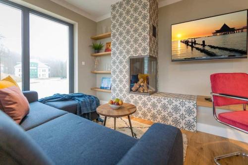 sala de estar con sofá azul y mesa en Villa Bellevue App 06, en Heringsdorf