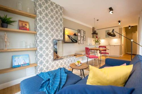 sala de estar con sofá azul y mesa en Villa Bellevue App 06, en Heringsdorf
