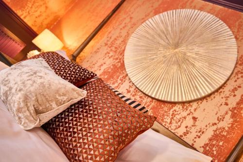 two pillows on a bed next to a fan at Little Hayes in Lyndhurst