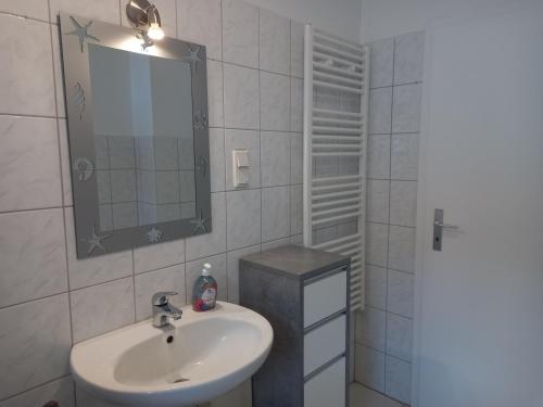 W białej łazience znajduje się umywalka i lustro. w obiekcie 1 Zimmer Appartment w mieście Springe