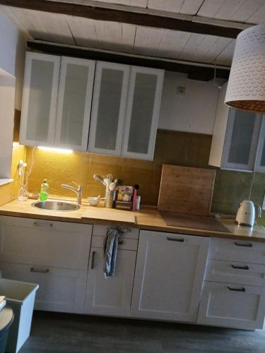 a kitchen with white cabinets and a sink at Strandhaus in Neubukow
