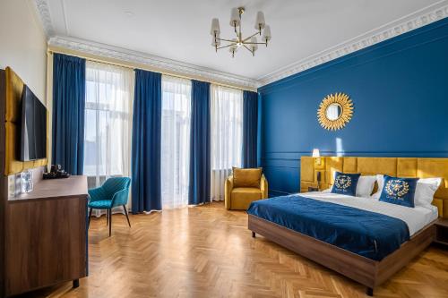 a blue bedroom with a bed and a chair at Queen Bee in Kyiv