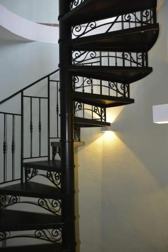 a black spiral staircase in a room with a light at GarganoMareBorghi ospitalità diffusa in Vico del Gargano