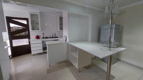 eine weiße Küche mit einer Theke und einem Kühlschrank in der Unterkunft Relaxing Holiday Home in Phuthaditjhaba