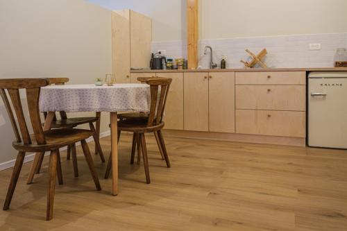 eine Küche mit einem Tisch und Stühlen sowie einem Kühlschrank in der Unterkunft הבקתה על השדות in Kefar Pines