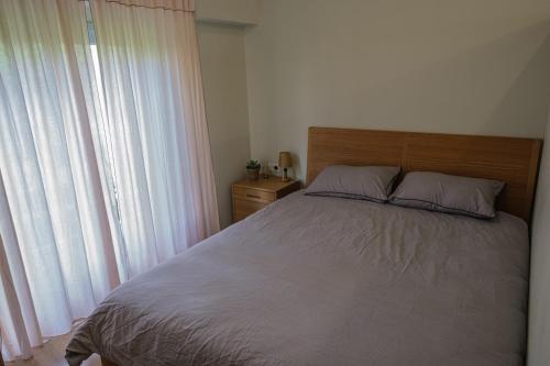 a bedroom with a bed and a large window at הבקתה על השדות in Kefar Pines