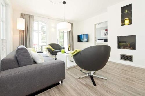 uma sala de estar com um sofá e uma cadeira em Ostseedomizil Bansin App 2 1 em Bansin