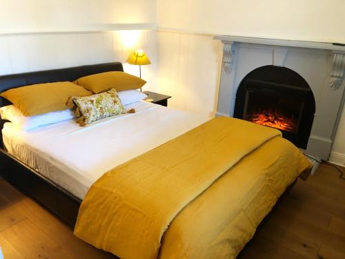 a bedroom with a large bed with a fireplace at Blue House Bendigo in Bendigo