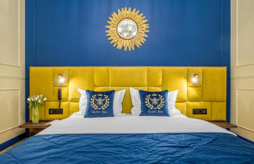 a bedroom with a large bed with a blue wall at Queen Bee in Kyiv