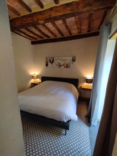 a bedroom with a white bed and two night stands at The View - Sunset & Relax - Suite - Appartamenti Vista Lago in Passignano sul Trasimeno