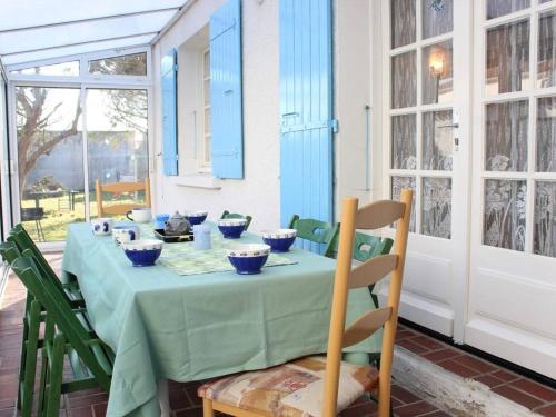 - une table avec des bols bleus dans une pièce dans l'établissement Maison charmante 8 pers avec internet fibre, à 300m du port et plage, parking, jardin, ménage inclus - FR-1-246A-34, à La Cotinière