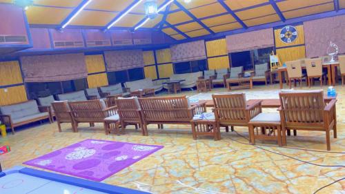 a dining room with wooden chairs and tables in a room at مزرعة السعادة للخيول(المدام) in Margham