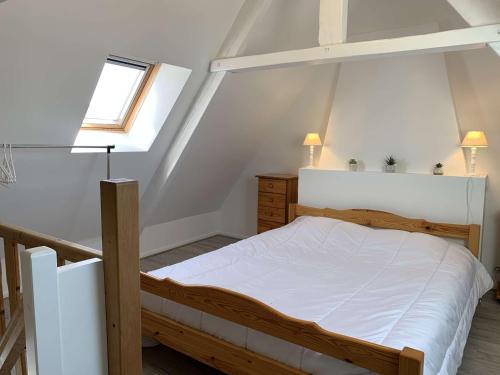 a bedroom with a wooden bed in a attic at Maison de pêcheur avec terrasse, à 450m de la plage et proche commerces à Trégastel - FR-1-368-363 in Trégastel