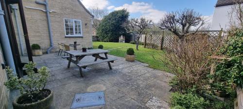a patio with a wooden picnic table in a yard at Yew Tree House in Woodstock