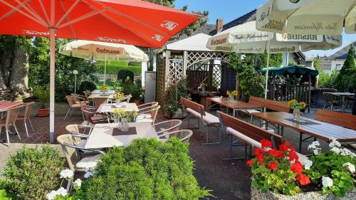 un patio con mesas, sillas y sombrillas en Hotel Gasthof Sonnenhang en Denkendorf