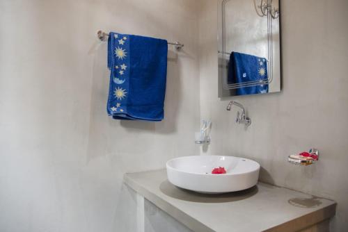 a bathroom with a white sink and blue towels at Villa Green Ice in Galle