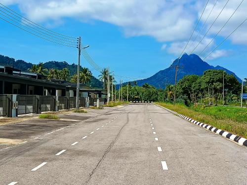 un camino vacío con una montaña en el fondo en ASFA Homestay Kuching, en Kuching