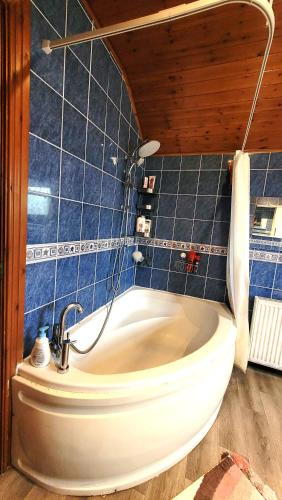 a bath tub in a bathroom with blue tiles at Another sweet home in Bradford