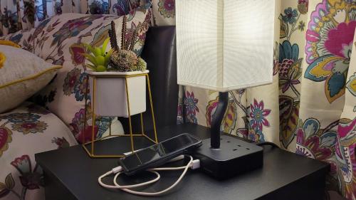 a lamp on a table with a phone on it at Another sweet home in Bradford