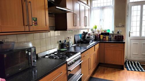 a kitchen with wooden cabinets and a stove top oven at Another sweet home in Bradford