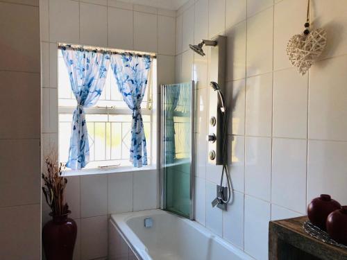 bagno con vasca e finestra di @ Home Bed & Breakfast a Brakpan