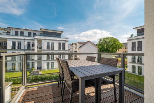 a deck with a table and chairs on a balcony at Villa Erika - App 5 in Ahlbeck