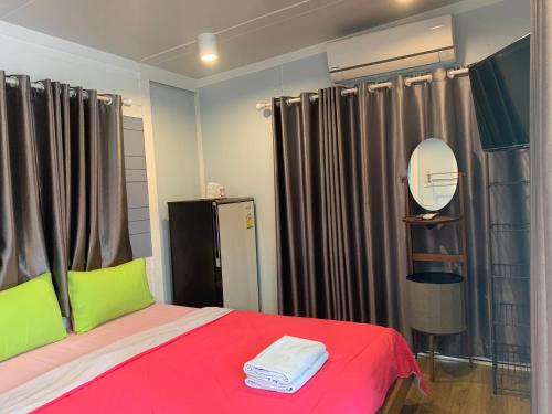 a bedroom with a bed with red and green at Rayonghouse Resort in Rayong