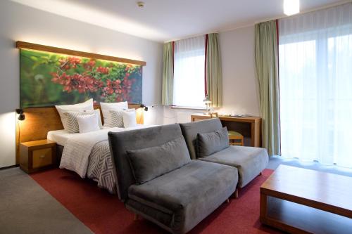 salon z łóżkiem i kanapą w obiekcie Hotel Szarlota - Kompleksowo na Kaszubach w Kościerzynie