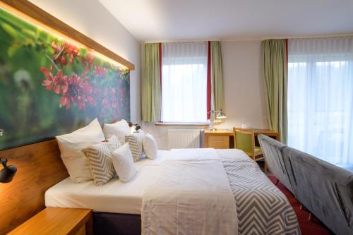 a hotel room with a bed with white sheets and pillows at Hotel Szarlota - Kompleksowo na Kaszubach in Kościerzyna