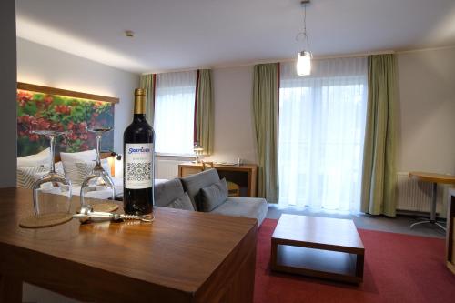 a living room with a bottle of wine on a table at Hotel Szarlota - Kompleksowo na Kaszubach in Kościerzyna