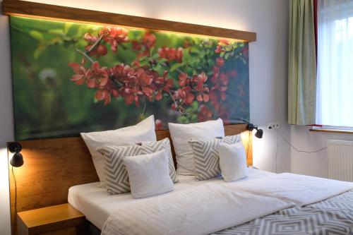 a bedroom with a bed with a painting on the wall at Hotel Szarlota - Kompleksowo na Kaszubach in Kościerzyna
