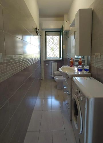 a bathroom with a sink and a washing machine at Residence Leonardo in Silvi Marina