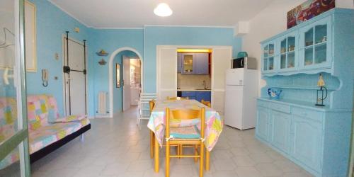 een blauwe kamer met een tafel en een keuken bij Residence Leonardo in Silvi Marina