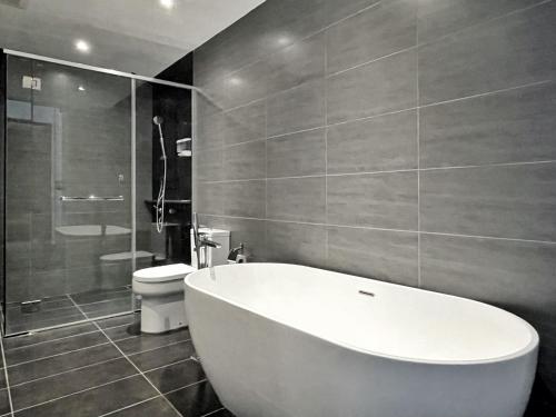 La salle de bains est pourvue d'une baignoire blanche et de toilettes. dans l'établissement ExpressionZ KLCC By Starwood Luxury, à Kuala Lumpur