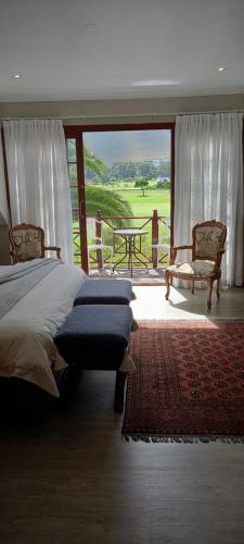 a bedroom with a bed and a balcony with a view at Mulligans Guest Lodge in Hermanus