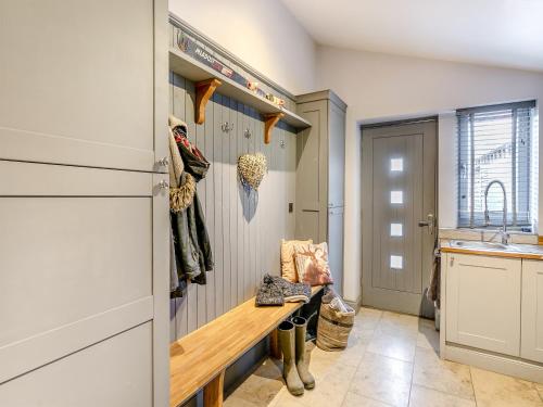 a kitchen with a bench in the middle of a room at Weavers Cottage in Marsden