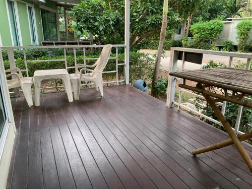 a porch with two chairs and a table and a bench at Rayonghouse Resort in Rayong