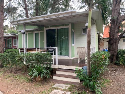 a small green house with a porch and stairs at Rayonghouse Resort in Rayong