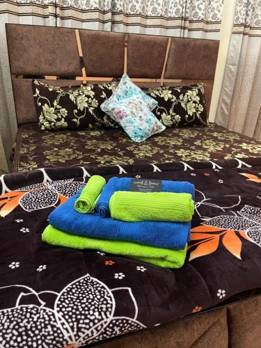 a pile of towels sitting on top of a bed at Dhairya's Villa Home Away From Home in Jammu