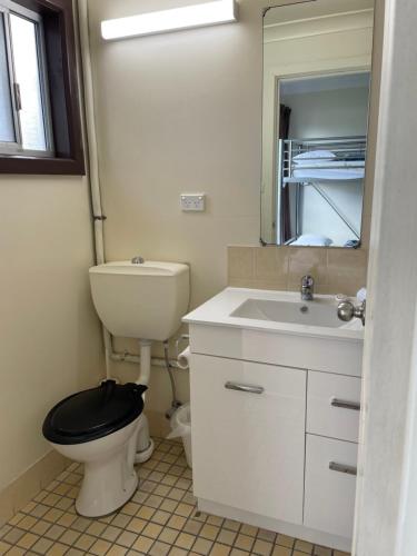 a bathroom with a toilet and a sink and a mirror at Siesta Villa in Jindabyne
