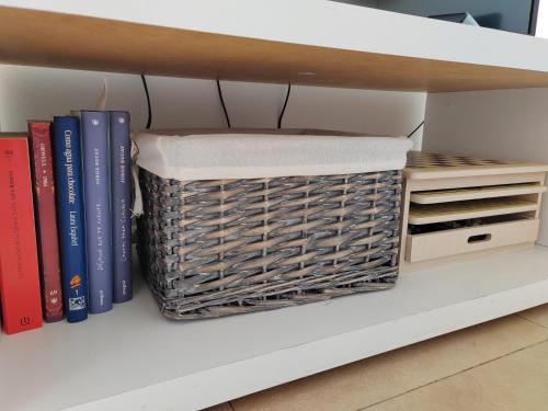 a basket sitting on a shelf with books at Exclusivo Atico con vistas en el centro de Lorca in Lorca