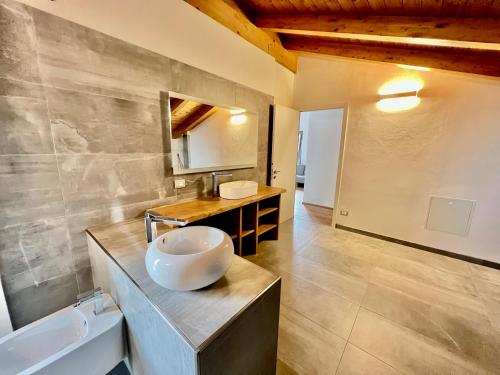 a bathroom with a sink and a bowl on a counter at Villetta famigliare a 10 minuti dal lago in Gargallo