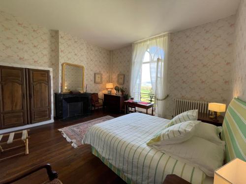 Schlafzimmer mit einem Bett, einem Schreibtisch und einem Fenster in der Unterkunft Château de Vaux 